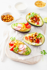 avocado boats stuffed with hummus, tomatoes, radish, roasted chickpea