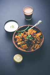 Homemade Kothu Parotta/ Paratha or Stir Fried Leftover Chapati Masala or  fodnichi poli in marathi, served in a bowl or plate with curd and hot tea. Selective focus