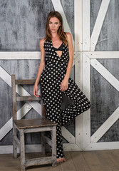 Young girl standing near the wall in a beautiful jumpsuit