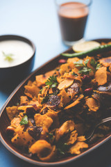 Homemade Kothu Parotta/ Paratha or Stir Fried Leftover Chapati Masala or  fodnichi poli in marathi, served in a bowl or plate with curd and hot tea. Selective focus