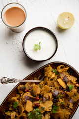 Homemade Kothu Parotta/ Paratha or Stir Fried Leftover Chapati Masala or  fodnichi poli in marathi, served in a bowl or plate with curd and hot tea. Selective focus