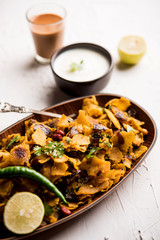 Homemade Kothu Parotta/ Paratha or Stir Fried Leftover Chapati Masala or  fodnichi poli in marathi, served in a bowl or plate with curd and hot tea. Selective focus