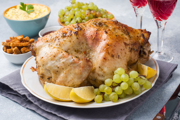 Baked chicken, mashed potatoes and wine glasses for dinner on the festive table.