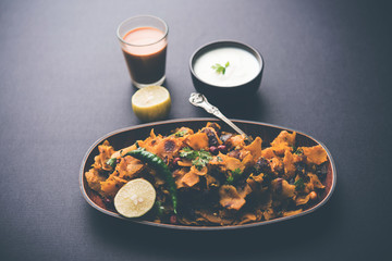 Homemade Kothu Parotta/ Paratha or Stir Fried Leftover Chapati Masala or  fodnichi poli in marathi, served in a bowl or plate with curd and hot tea. Selective focus
