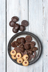 shortbread butter cookies with chocolate and plum jam on a white wooden table