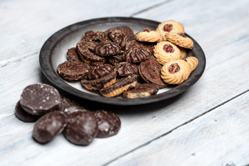 shortbread butter cookies with chocolate and plum jam on a white wooden table