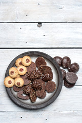 shortbread butter cookies with chocolate and plum jam on a white wooden table