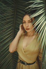 Stunning Woman Posing on Palm Leaves Background