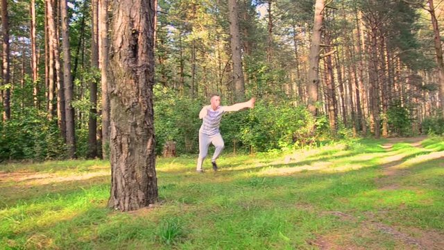 young guy jumps and does a flip in the forest