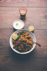 Homemade Kothu Parotta/ Paratha or Stir Fried Leftover Chapati Masala or  fodnichi poli in marathi, served in a bowl or plate with curd and hot tea. Selective focus