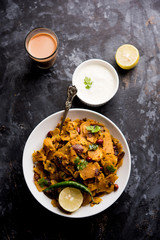Homemade Kothu Parotta/ Paratha or Stir Fried Leftover Chapati Masala or  fodnichi poli in marathi, served in a bowl or plate with curd and hot tea. Selective focus