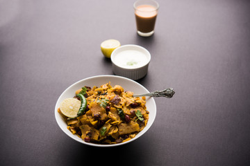 Homemade Kothu Parotta/ Paratha or Stir Fried Leftover Chapati Masala or  fodnichi poli in marathi, served in a bowl or plate with curd and hot tea. Selective focus