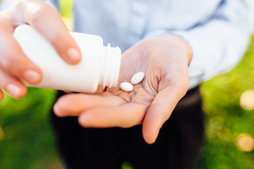 hands holding a jar with pills, closeup