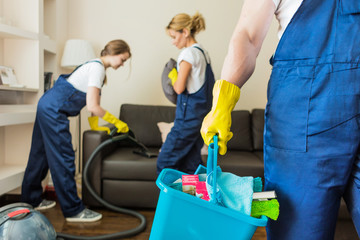 Cleaning service with professional equipment during work. professional kitchenette cleaning, sofa dry cleaning, window and floor washing. man and women in uniform, overalls and rubber gloves