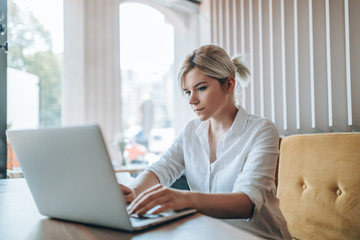 Beautiful girl drinking coffee and sending emails