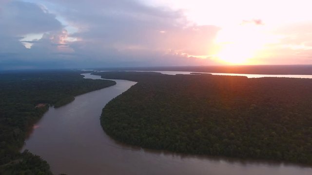 Flying over Mana river Guiana Suriname during sunset. Amazonian forest 