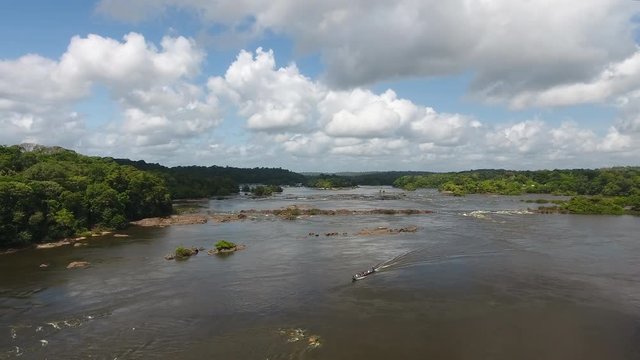 Motorised pirogue (dugout canoe) descending rapids (saut Maripa) Oiapoque River by drone. Brazil Guiana