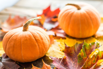 orange pumpkins with leaves on wooden background