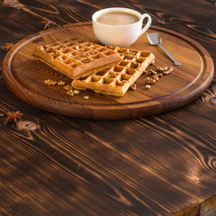 fresh belgian waffles, tasty jam and latte coffee on a wooden background. top view.