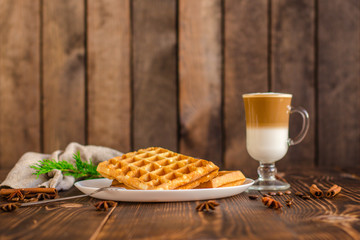 fresh belgian waffles, tasty jam and latte coffee on a wooden background. top view.