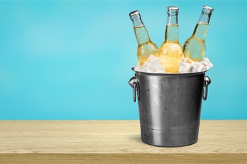 Beer bottles in ice on beach background