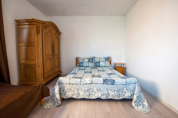 Wide angle view of a traditional English bedroom with patchwork quilts