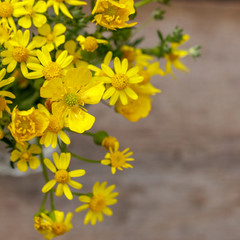 beautiful yellow bouquet of flowers stands on a wooden background, copy space