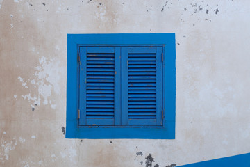 Blue wood window on an old white wall
