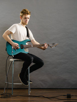 Young man playing electric guitar
