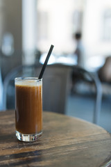 chocolate drink in a glass with ice on a table
