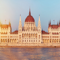 Fototapeta na wymiar Parliament building in Budapest, Hungary. Building facade with reflection in water. Beautiful sunset light