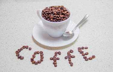 Coffee beans in a white Cup. Scattered coffee beans