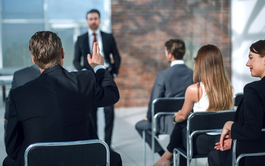 staff member raises a hand at a conference to answer a question