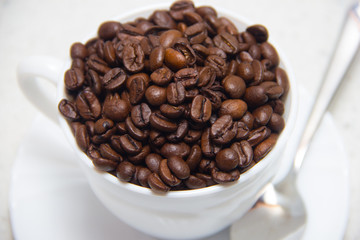 Coffee beans in a white Cup. Preparation of coffee. Close up