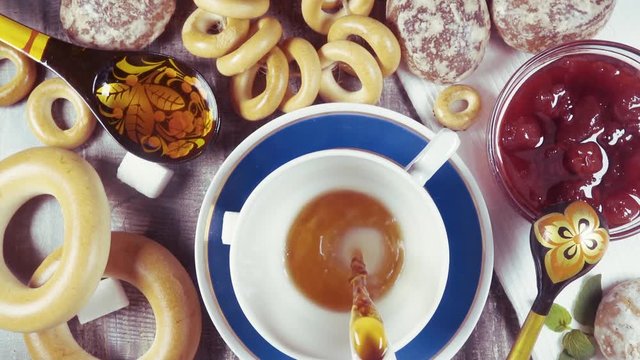 Slow motion traditional Russian tea party with Sushki, bagels Baranka and jam with gingerbread Pryanik top view