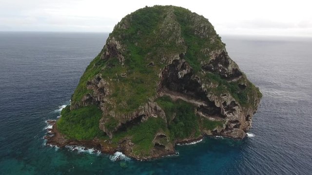 Aerial drone shot during cloudy day. Flying around le rocher diamant in Martinique. Natural bird reserve.