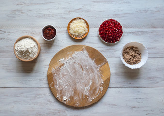 Preparation of traditional Arabic pizza manaqish with meat and pomegranate.
