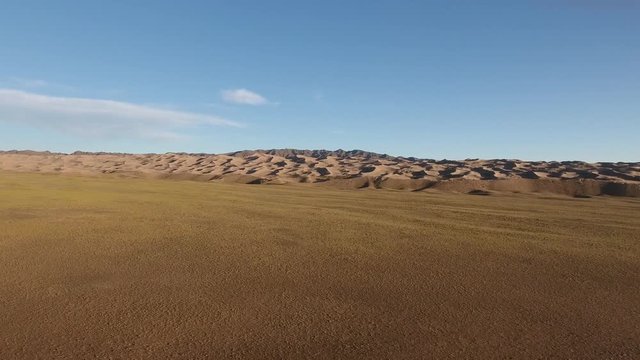 Aerial drone shot speedup over steppe in direction of sand dunes mongolia