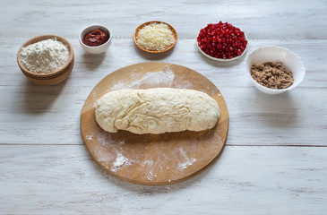 Preparation of traditional Arabic pizza manaqish with meat and pomegranate.
