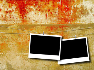Two blank rectangular instant photo frames against brown red dirty weathered concrete wall background
