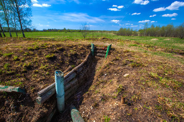 The deep trenches of the Second World War fortified with wood, red carnations in memory of the victims. Military trenches near the city of Volokolamsk at Dubosekovo junction, Moscow Region, Russia.