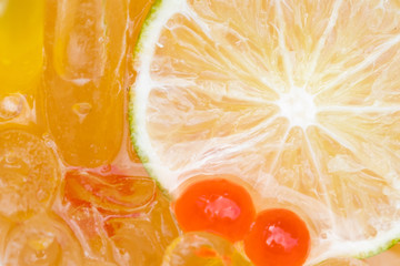 Plakat close-up slide lemon, ice and sweet ball of honey lemon ice tea. Top view