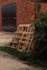 Fototapeta na wymiar wooden pallets leaning against a brick wall