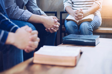 Obraz premium Christian group are praying together around wooden table with holy bible