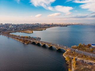Aerial view of Vograsovsky bridge with car traffic connecting Left Bank and Leninsky districts of Voronezh, panoramic view at sunset