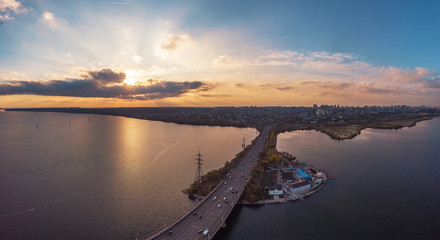 Aerial view of Vograsovsky bridge with car traffic connecting Left Bank and Leninsky districts of Voronezh, panoramic view at sunset
