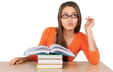 Beautiful young female student daydreaming while studying