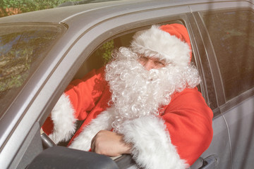 A man dressed as Santa Claus delivers gifts on the car. Stress and road problems