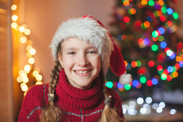 Smiling girl near christmas tree at home