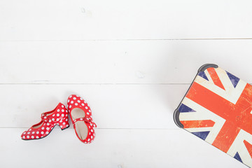 red colorful children's shoes in the peas. Modern stylish trendy trendy multicolor. lie on the white floor next to the flag of Great Britain
